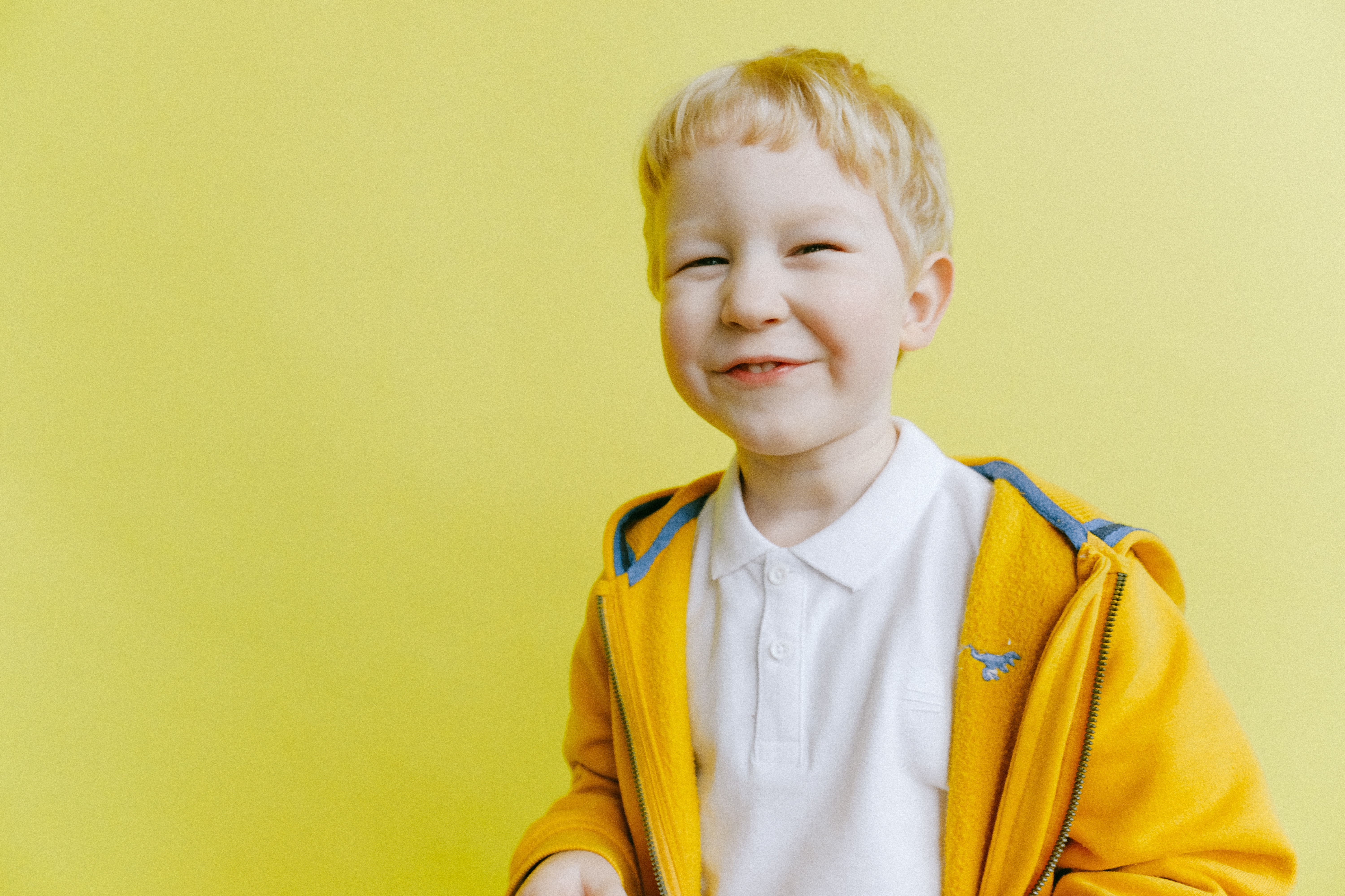 A happy looking child wearing yellow