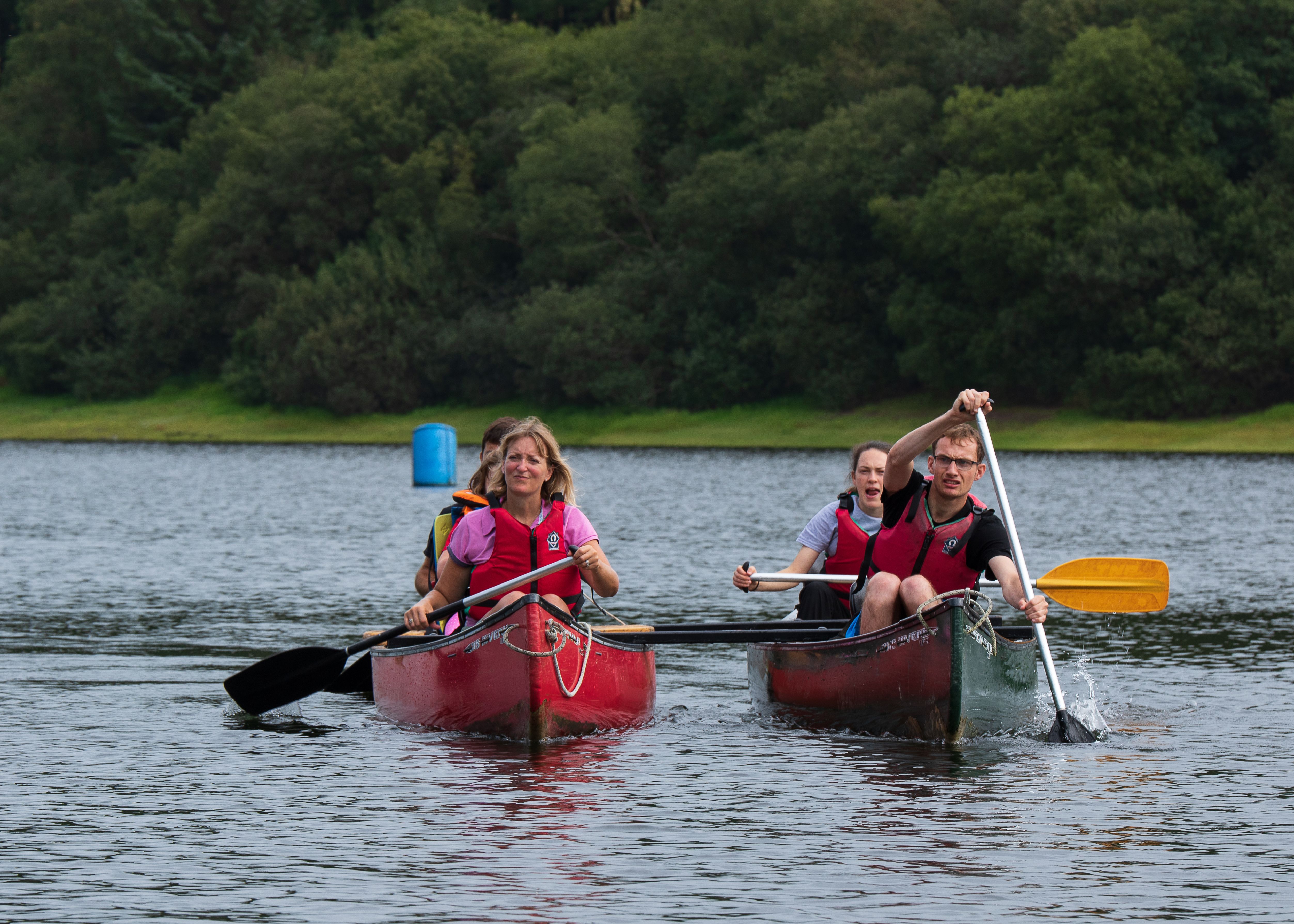Two groups canoeing around the reservoir at Calvert Trust Exmoor