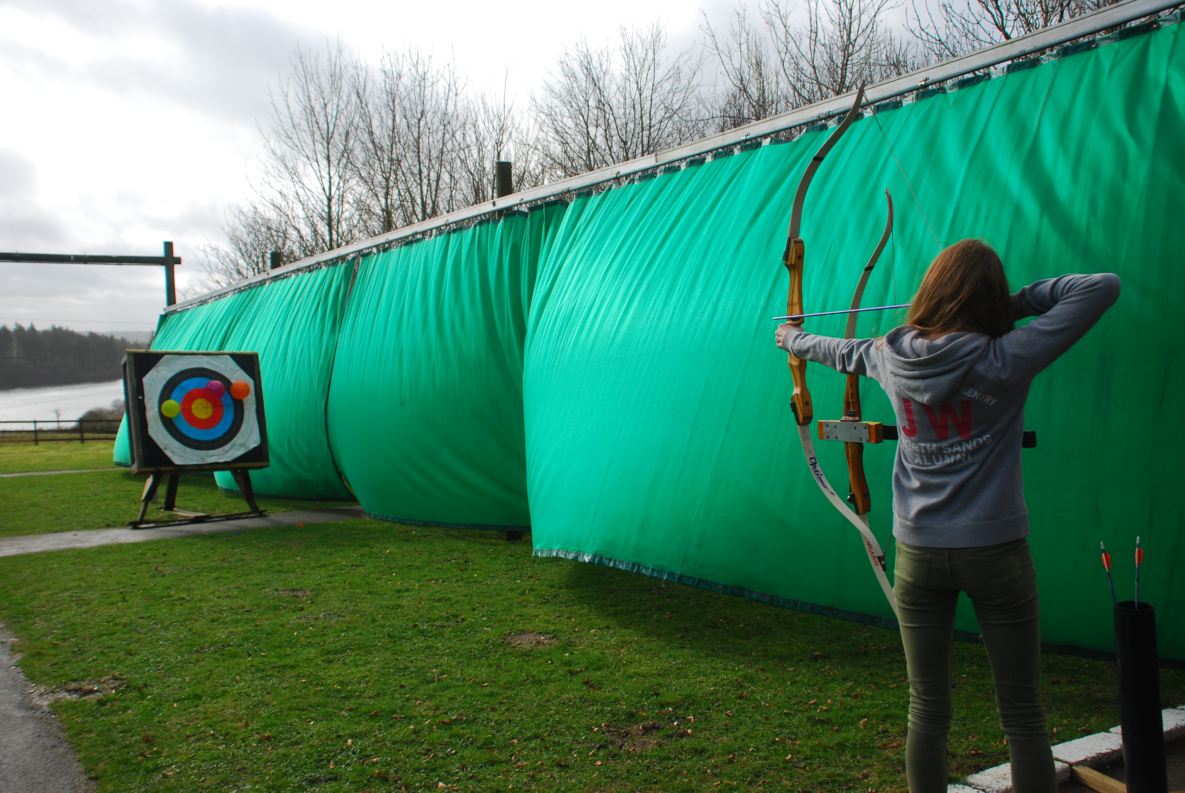 A Calvert Exmoor guest aiming an arrow at balloons on a target