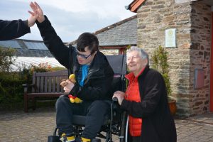 A man in a wheelchair giving a lady a high five