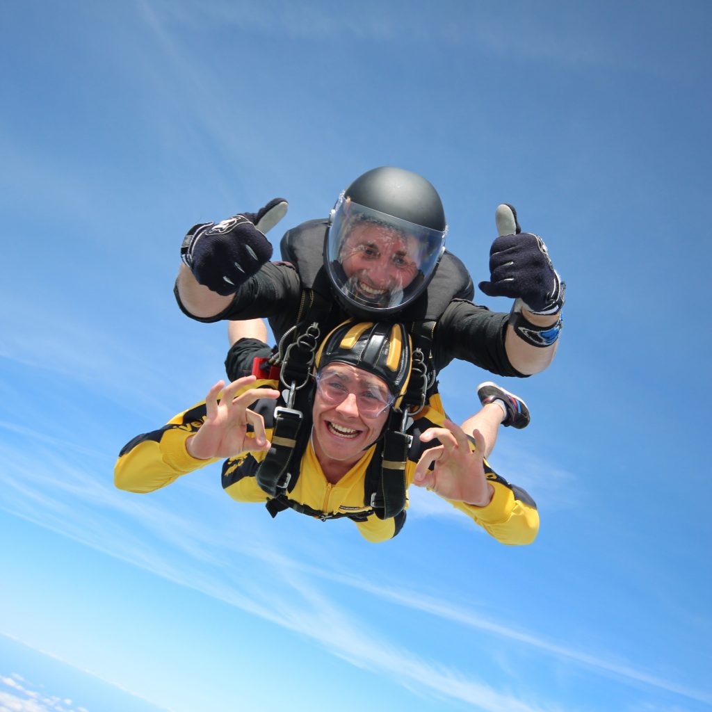 Two men strapped together soaring through the sky