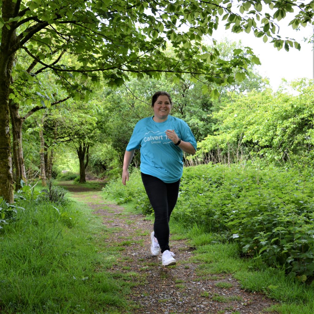 Girl running through woodland in blue t-shirt