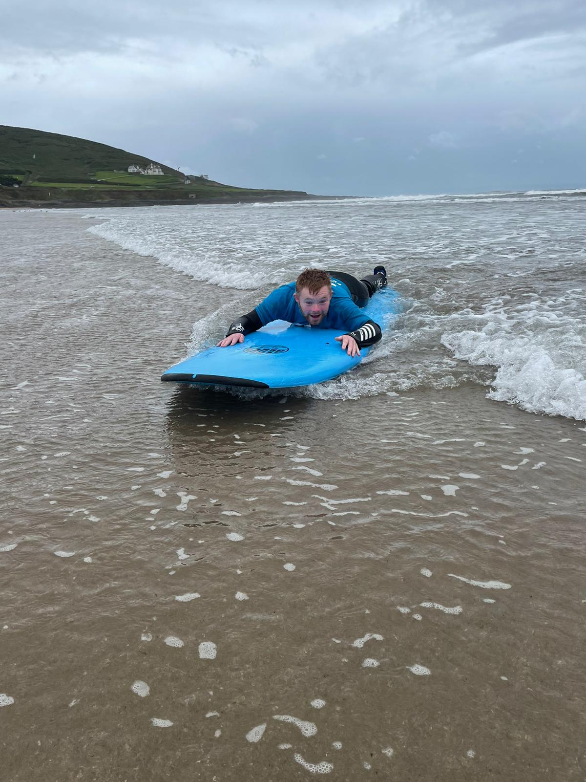 Someone on a Calvert Exmoor holiday on a surfboard at the beach