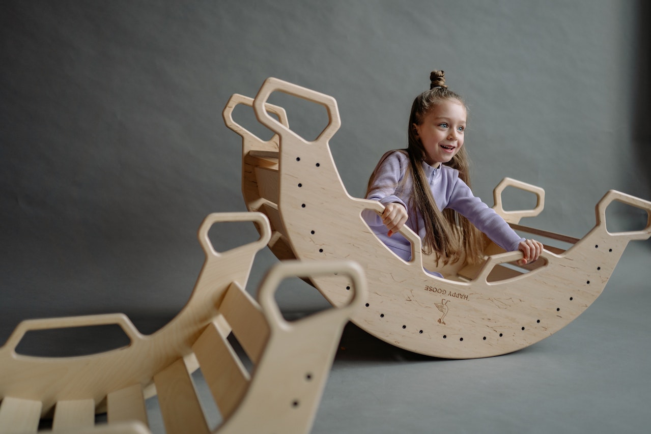 A child on a wooden rocking toy