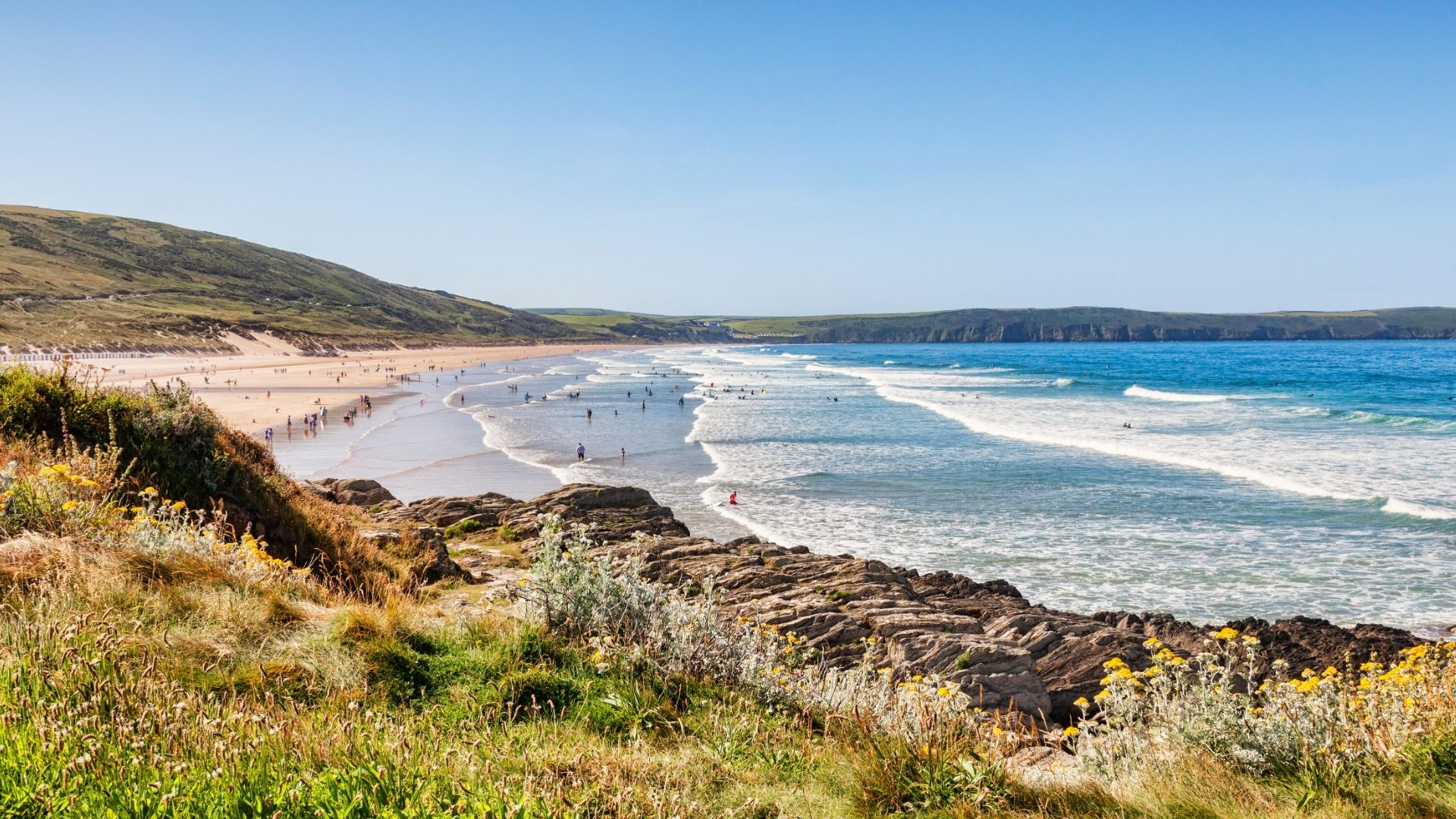 Stock image of Woolacombe Beach in North Devon with blue seas yellow sand and green hills