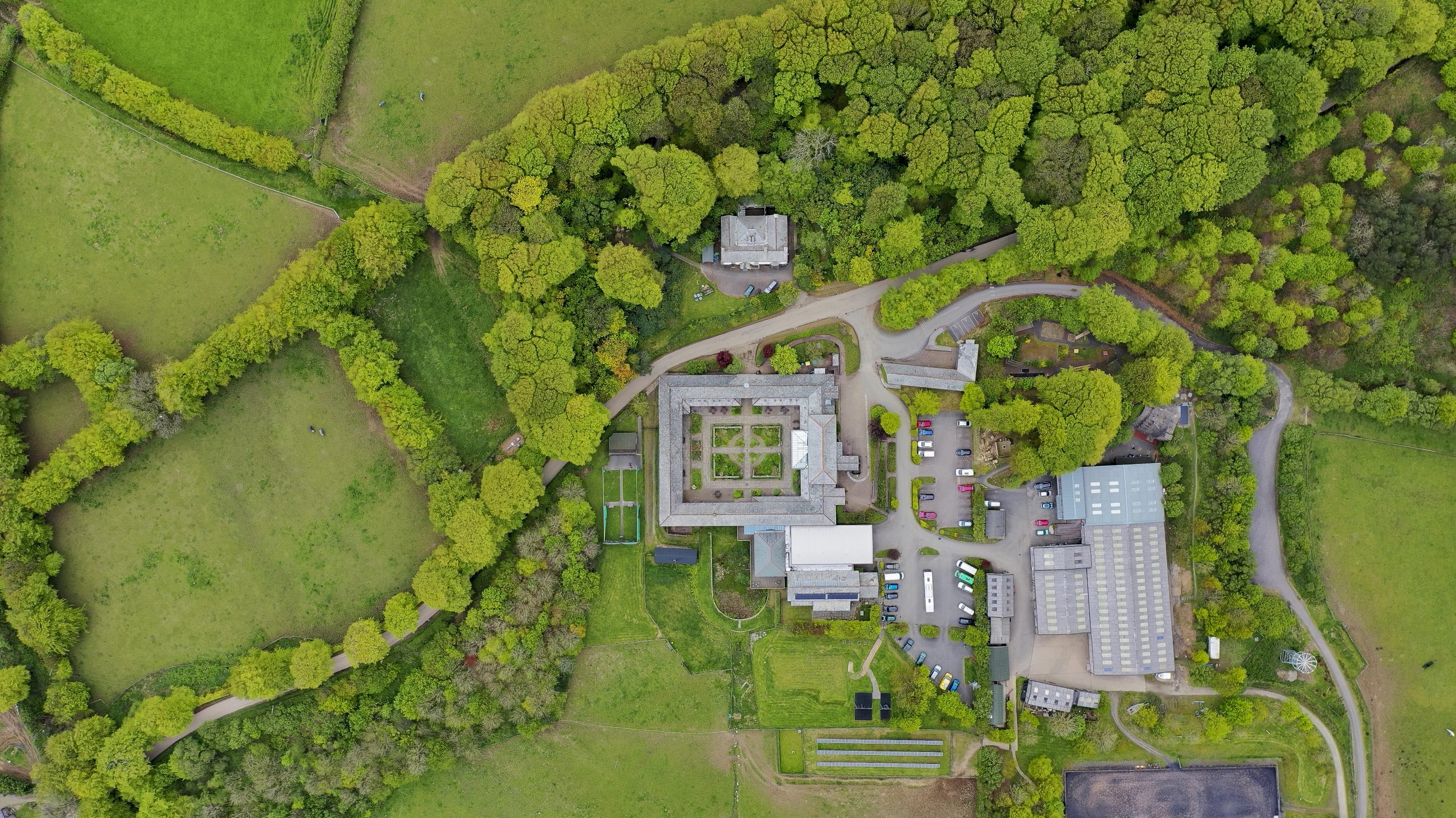 An aerial image directly above Calvert Exmoor, showing land, trees and the buildings including the courtyard accommodation area.