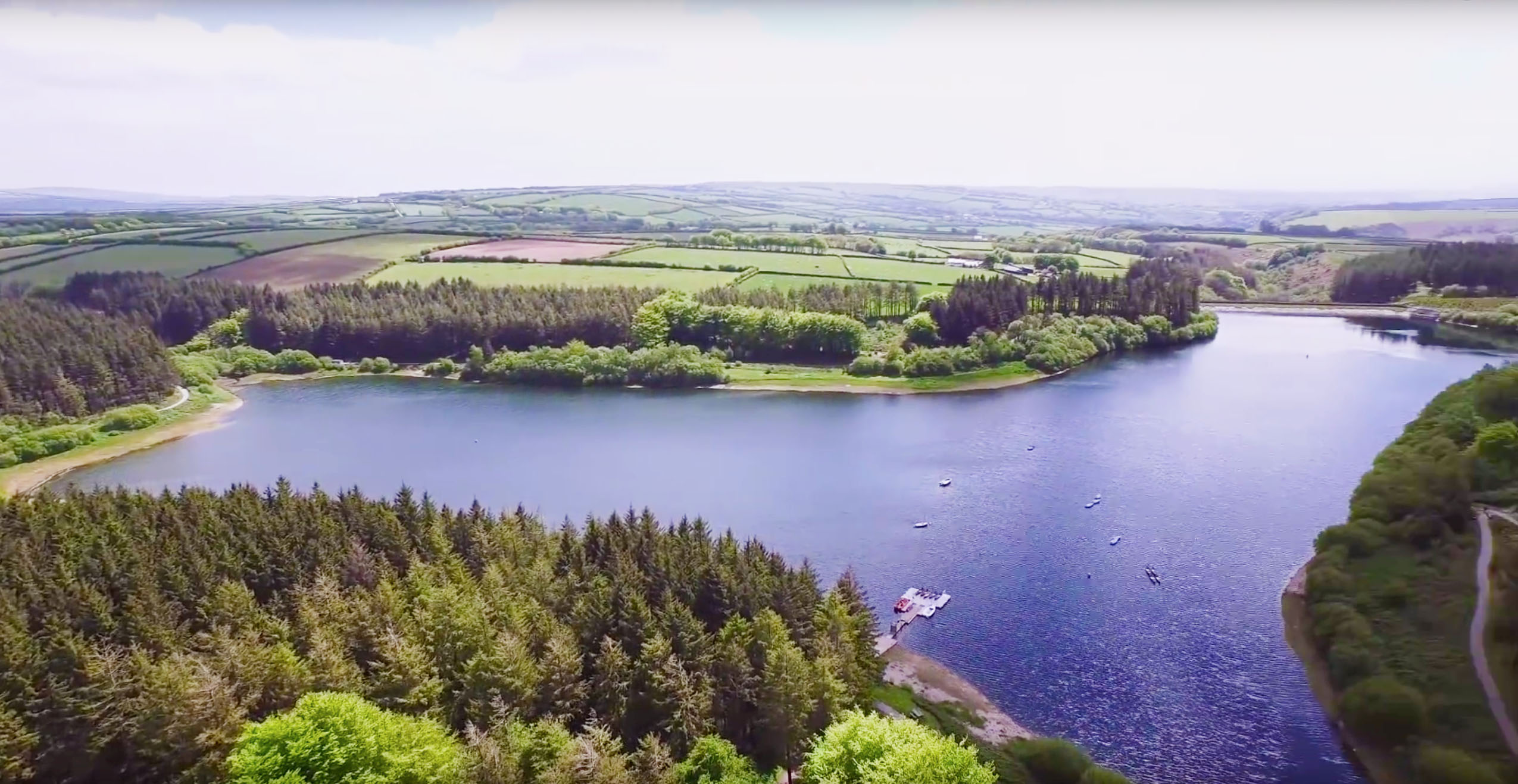 Ariel view of Wistlandpound Reservoir blue water surrounded by green countryside