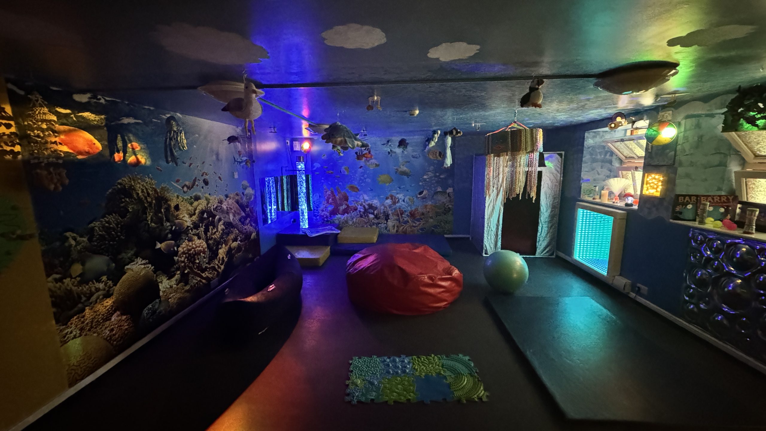 A darkened room with multi-coloured lights and sensory decorations.